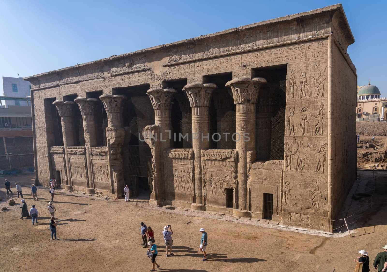 Esna, Egypt - 3 November 2024: Tourists admire the well-preserved facade of the Temple of Esna, a Greco-Roman temple in Egypt.
