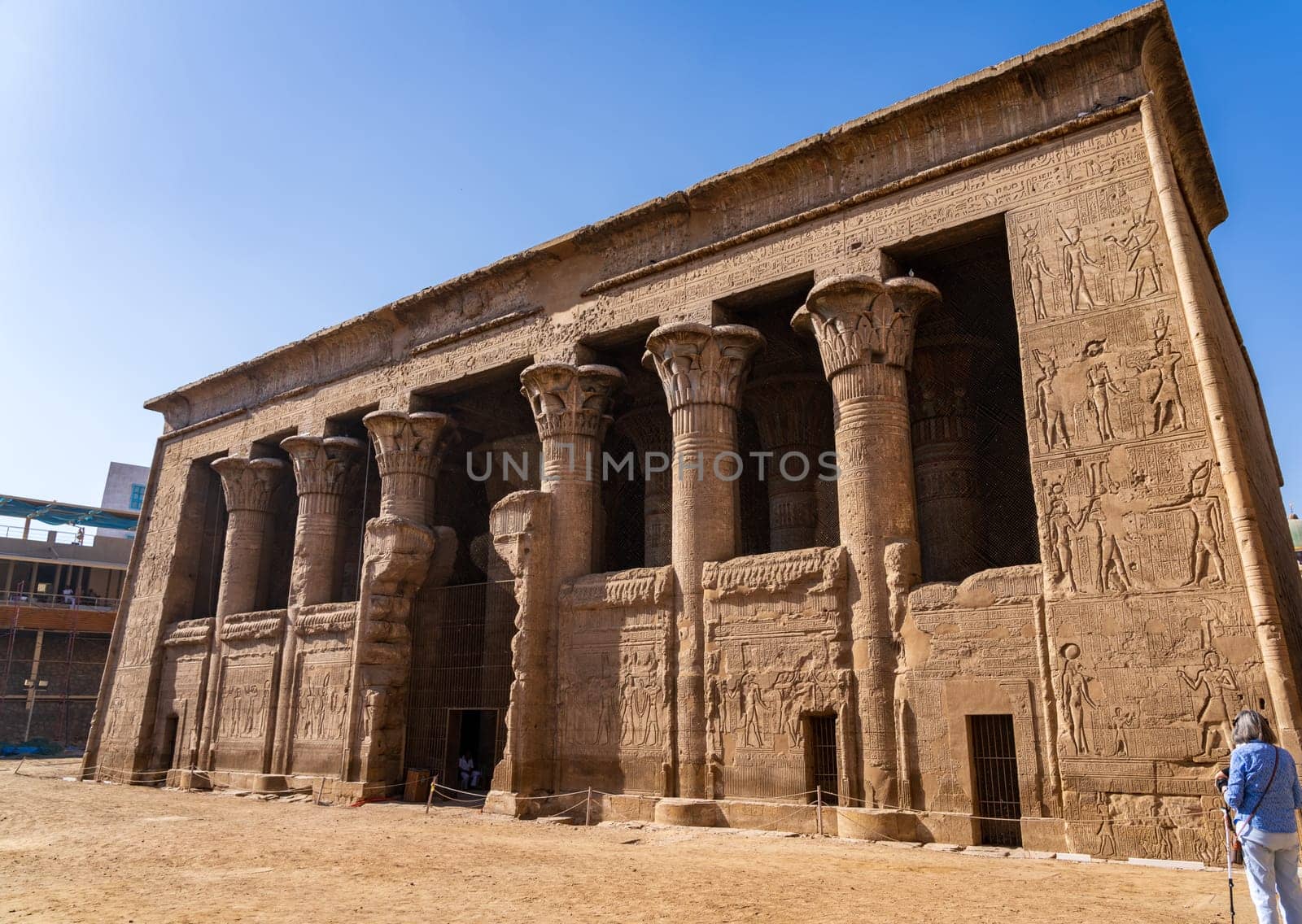 Tourists admire the well-preserved facade of the Temple of Esna, a Greco-Roman temple in Egypt.