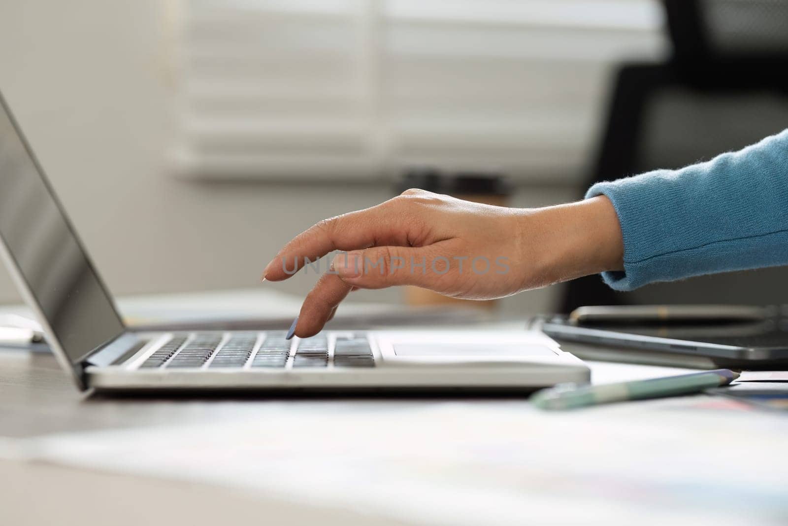 An individual engages intently with their laptop keyboard, enhancing their creative workflow while managing design tasks in a modern setting.