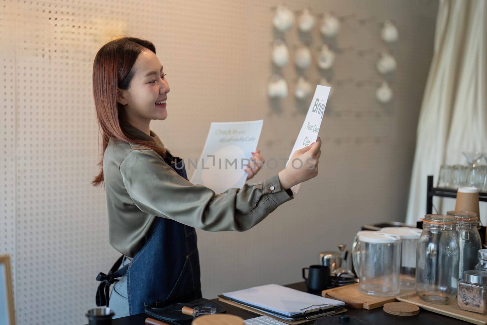 A barista beams as she holds up a sign promoting eco-friendly practices, reinforcing the cafe commitment to sustainability.