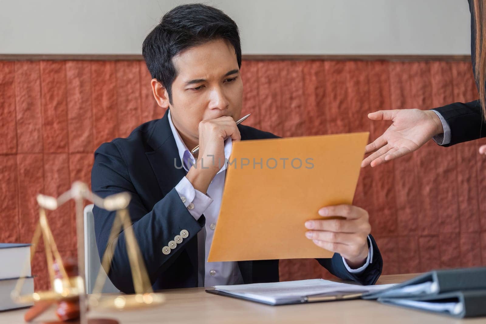 The client carefully analyzes a legal paper during a consultation, seeking clarity and understanding with the attorney's assistance.