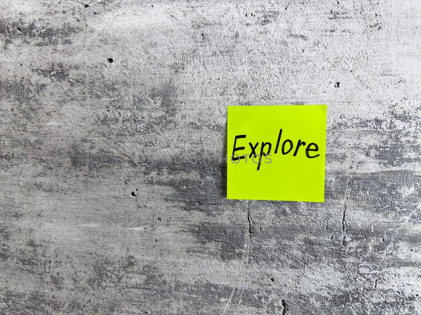 Vibrant green sticky note featuring the word Explore on a textured grey background, symbolizing curiosity, adventure, and the spirit of discovering new experiences