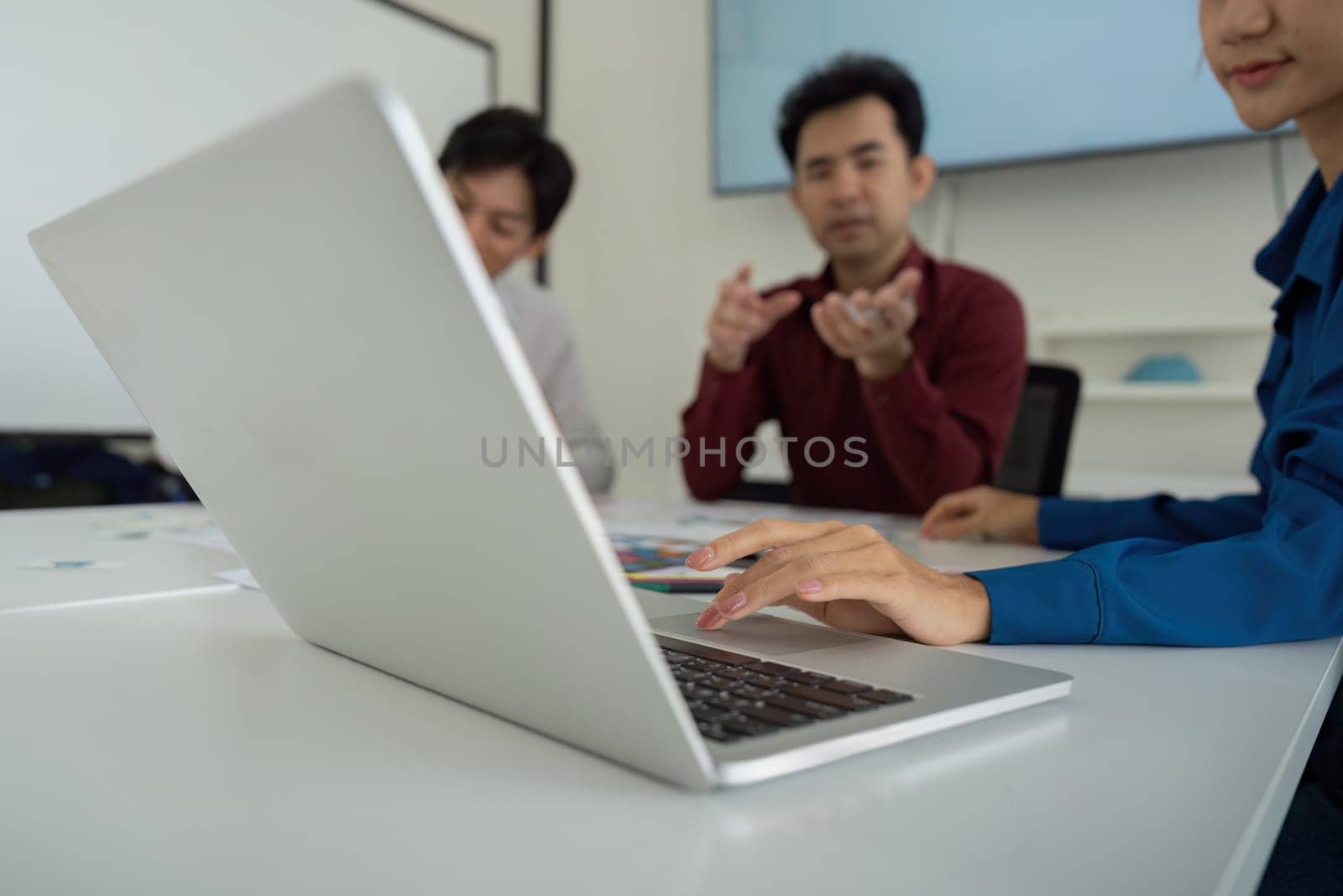 A focused meeting with team members reviewing the UX strategies on a laptop, engaging in meaningful discussions about design improvements.