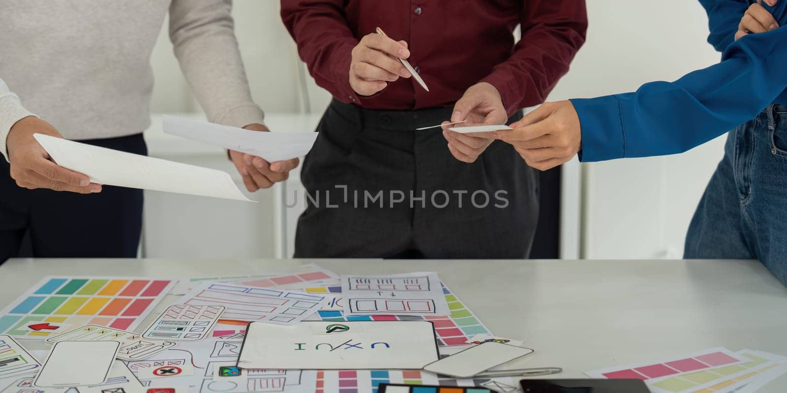 A UX team assessing design ideas and usability features, with a focus on creative problem-solving and collaboration to finalize their proposals.