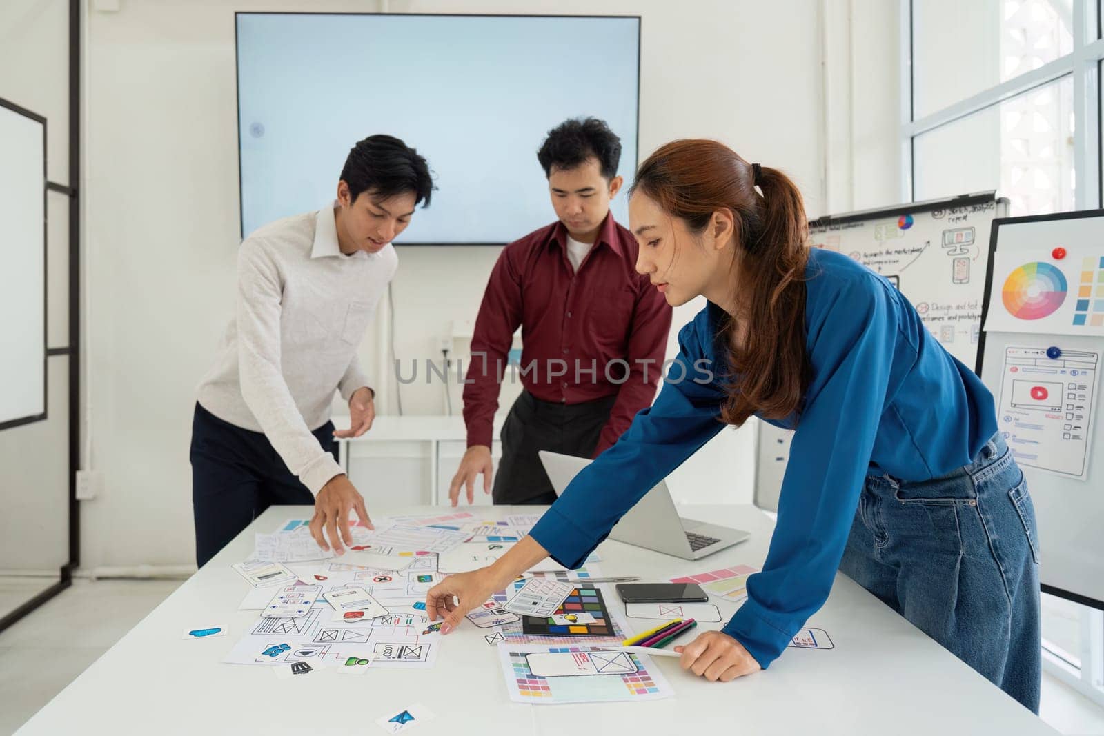 A team of designers diligently creates prototypes for a new application, focusing on usability and aesthetic appeal. Their hands-on approach ensures each detail aligns with user needs.