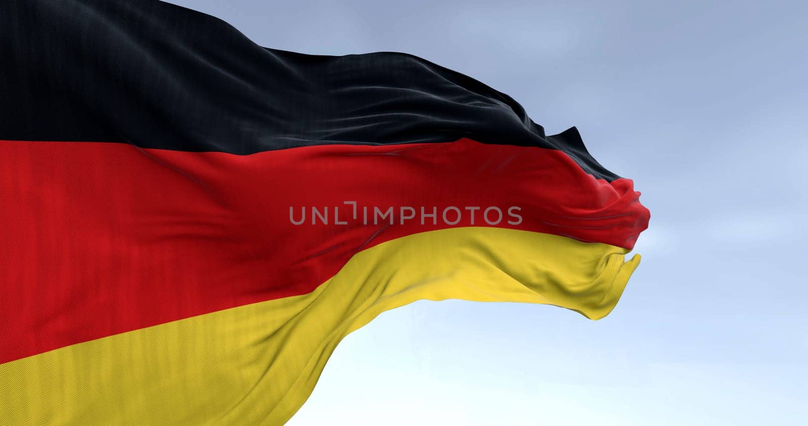 Close-up of Germany national flag waving in the wind on a clear day. Three horizontal bands of black, red and gold. 3d illustration render. Rippled fabric. Selective focus