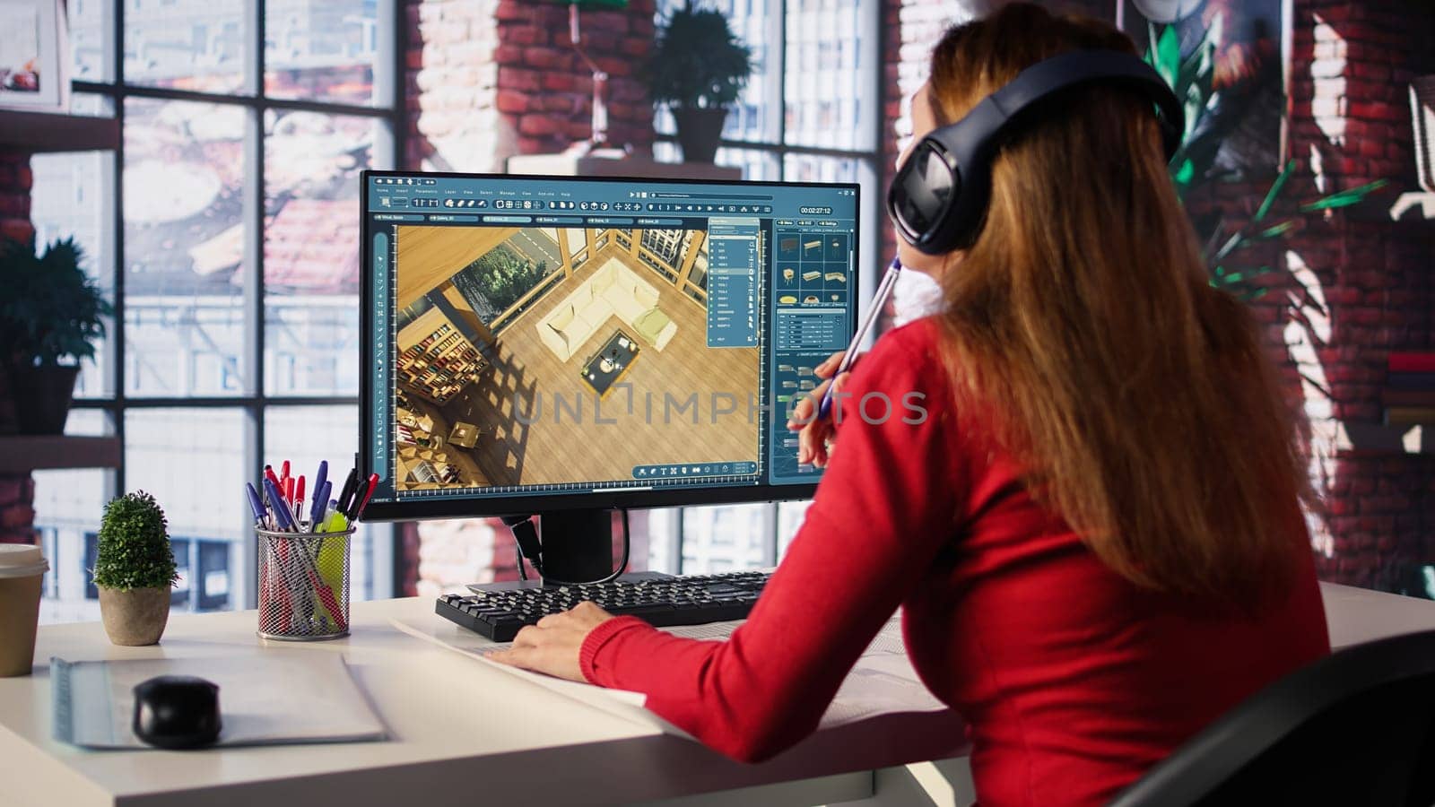 Female employee creates 3D render of an apartment interior using blueprints and architectural software. Employs computer aided tools and models to allow customization of flooring. Camera B.