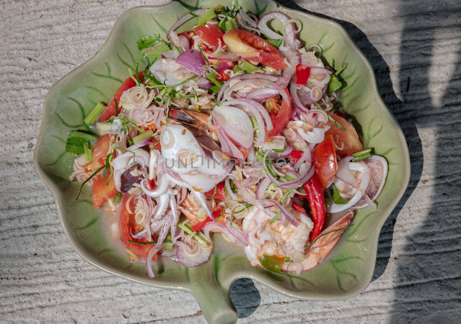 Top view of Spicy seafood salad with Lemongrass (Thai style spicy) on Ceramic plate. use it as your Wallpaper, Poster and Copy space, Selective focus.
