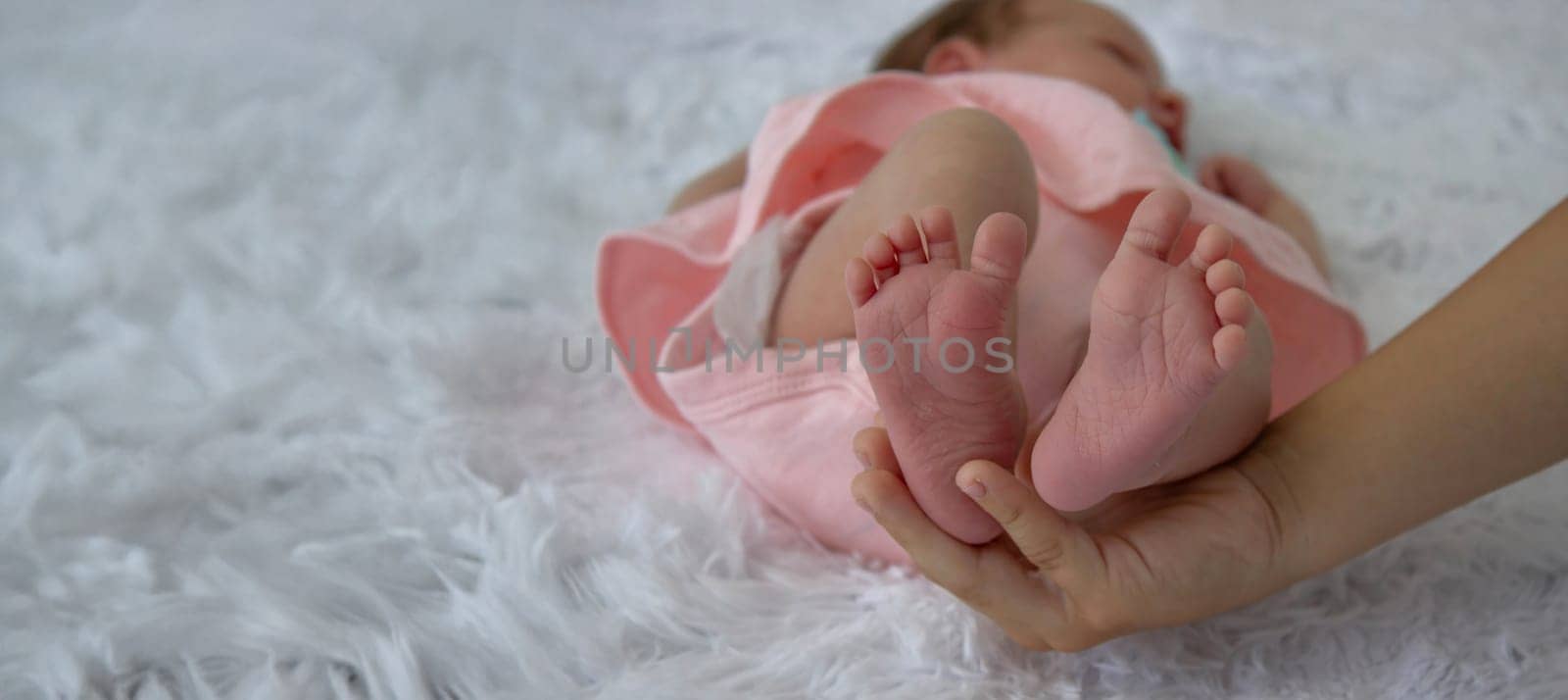 close-up of boy, brother holding baby girl's legs