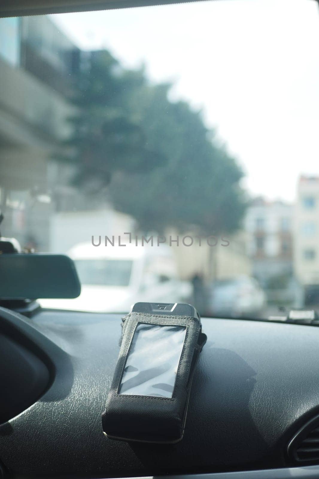 A pos machine rests on a car dashboard