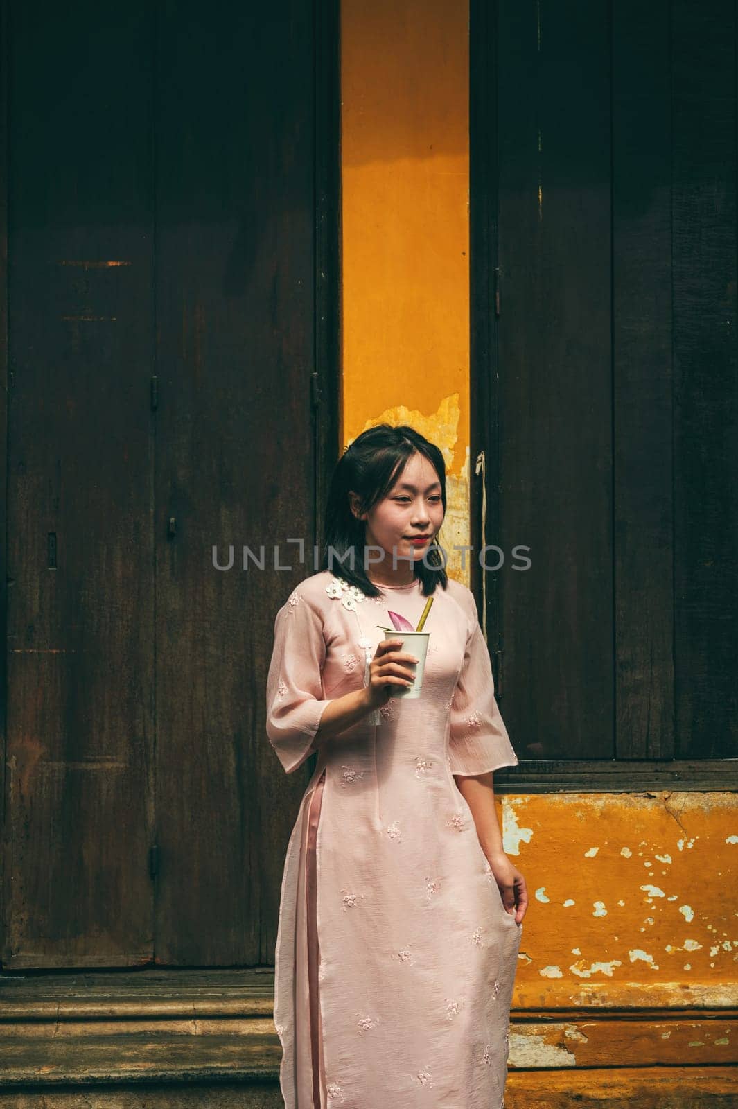 Beautiful young Asian girl Vietnamese tourist on the street in the old town in Hoi An in Vietnam. Hoi An, Vietnam - December 1, 2024