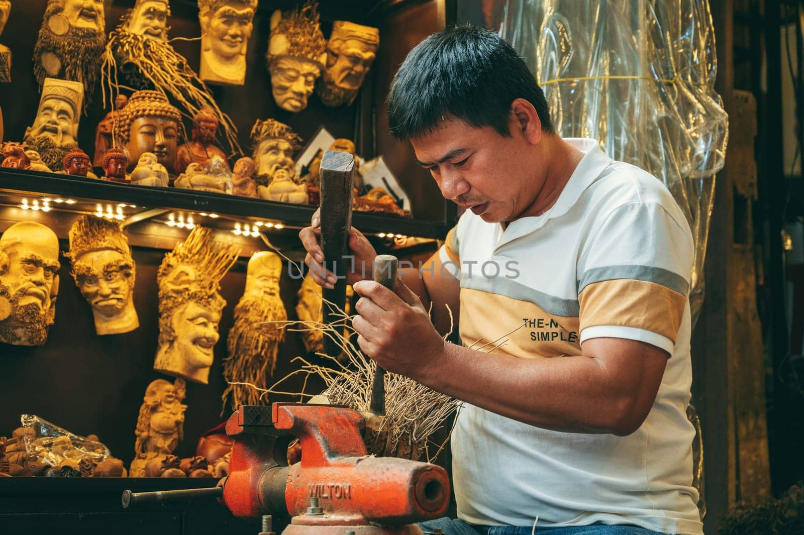Asian male artisan craftsman carpenter works in wood carving workshop carpentry on street in old town in Hoi An city in Vietnam. Hoi An, Vietnam - December 1, 2024