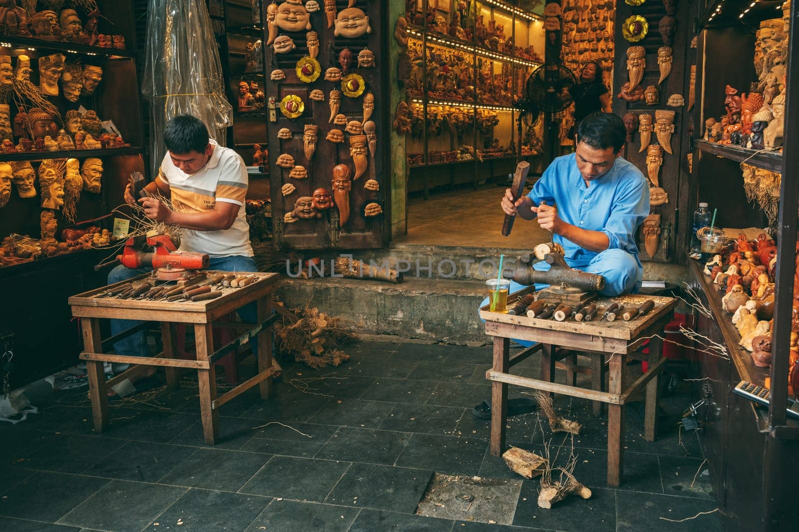 Asian men artisans craftsman carpenters works in a wood carving workshop carpentry on a street in Hoi An city in Vietnam in Asia. Hoi An, Vietnam - December 1, 2024
