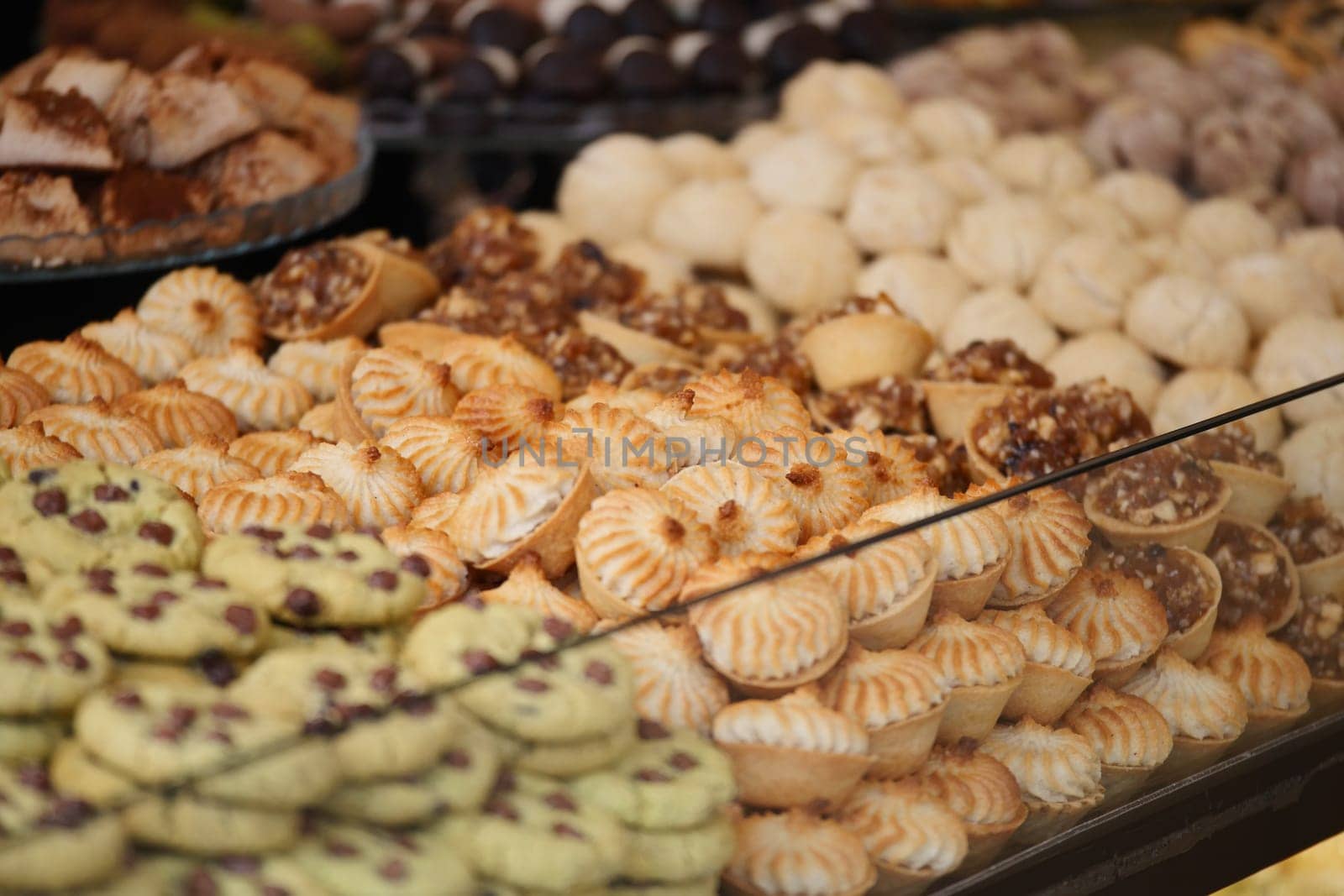 Colorful selection of various traditional sweets arranged in a shop display.