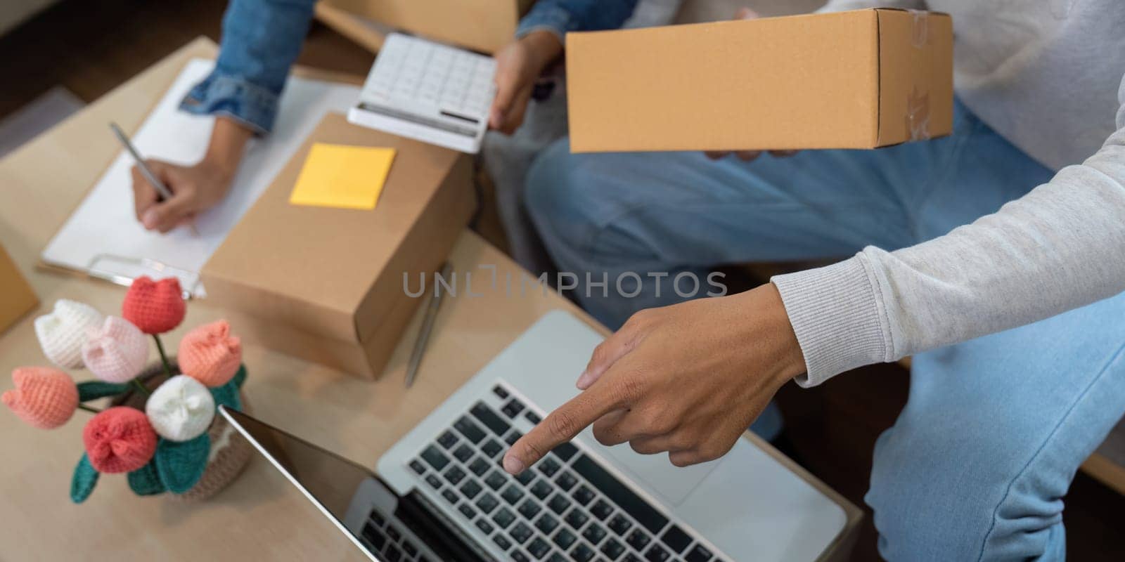 They are meticulously packing products for shipment, highlighting their commitment to quality service in their home-based e-commerce venture.
