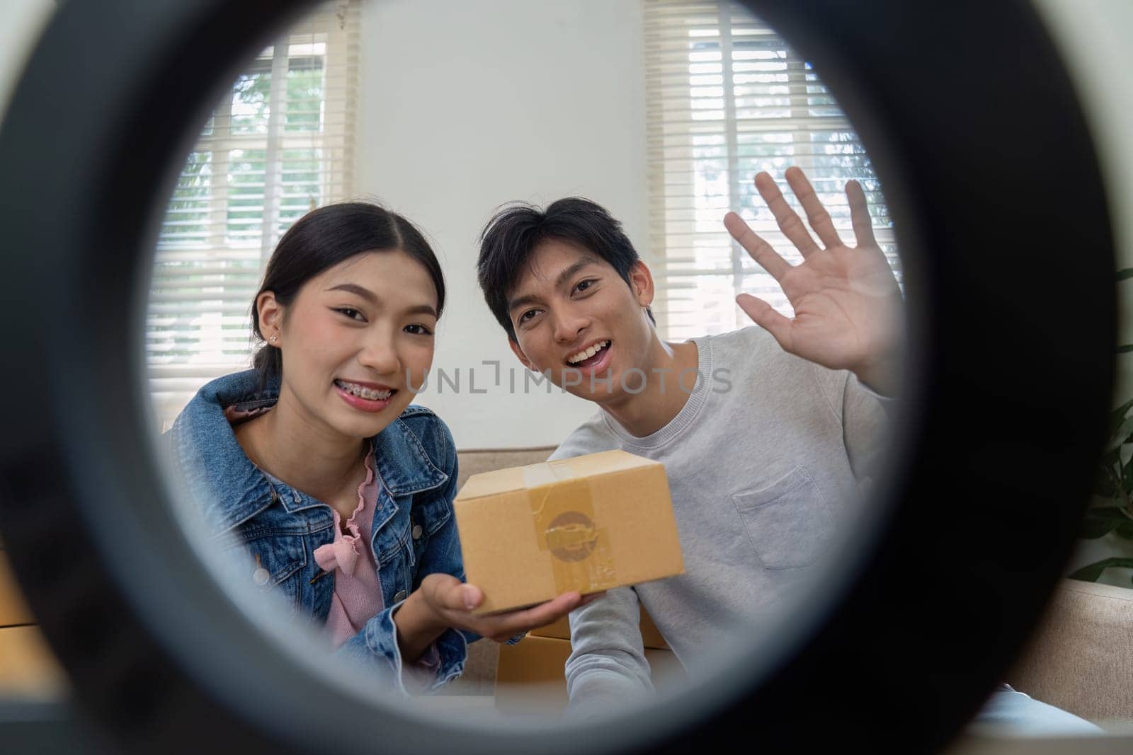 In a candid shot, the couple poses with a product box, highlighting their enthusiasm and readiness for an online presentation, embodying the spirit of marketing and promotion.