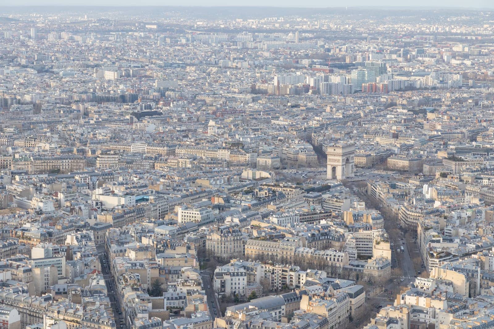 Paris city panorama with Arc de Triomphe, the aerial view from the Eiffel tower in soft evening light in early spring