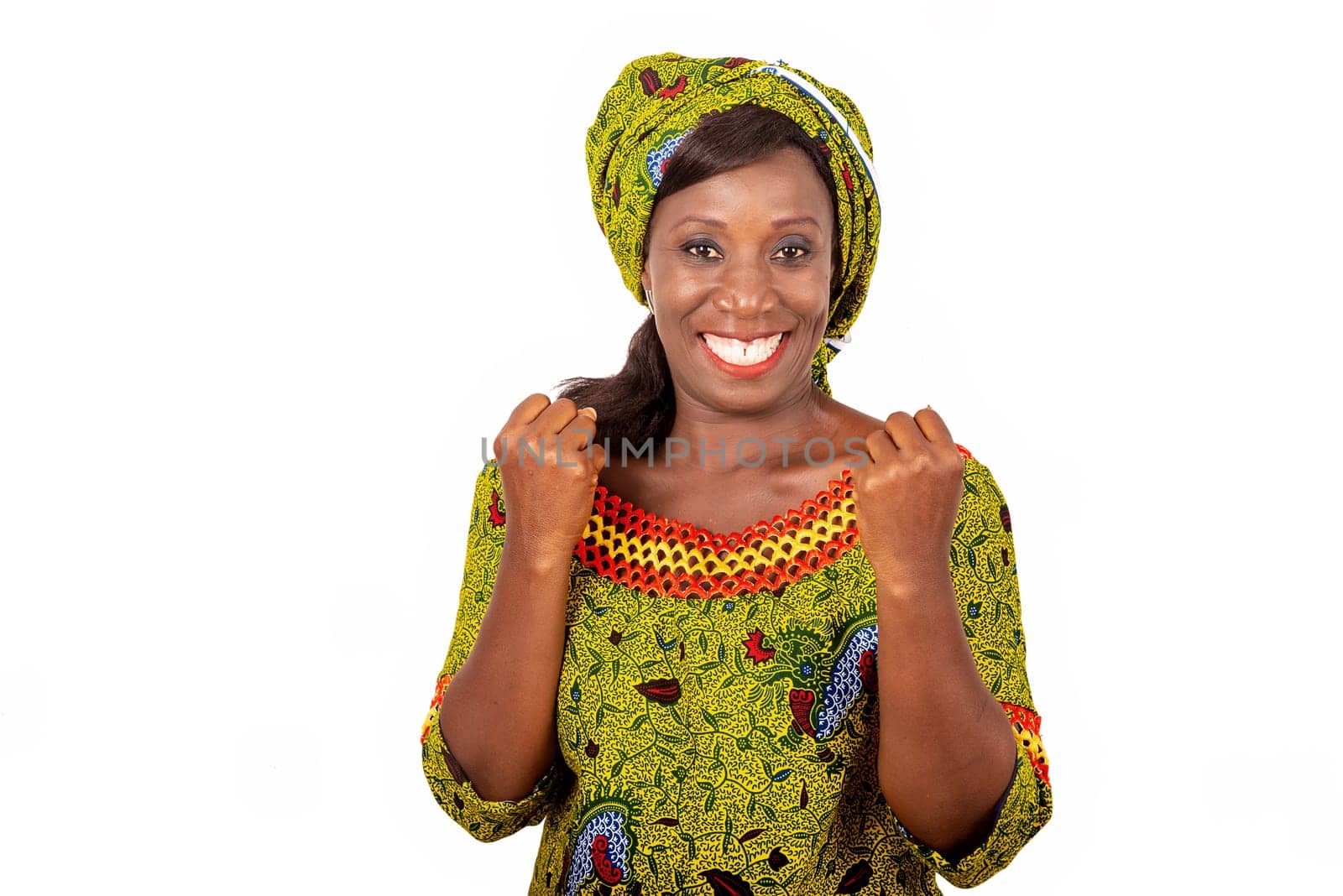 beautiful African adult woman dressed in green loincloth shows her victory by raising both arms