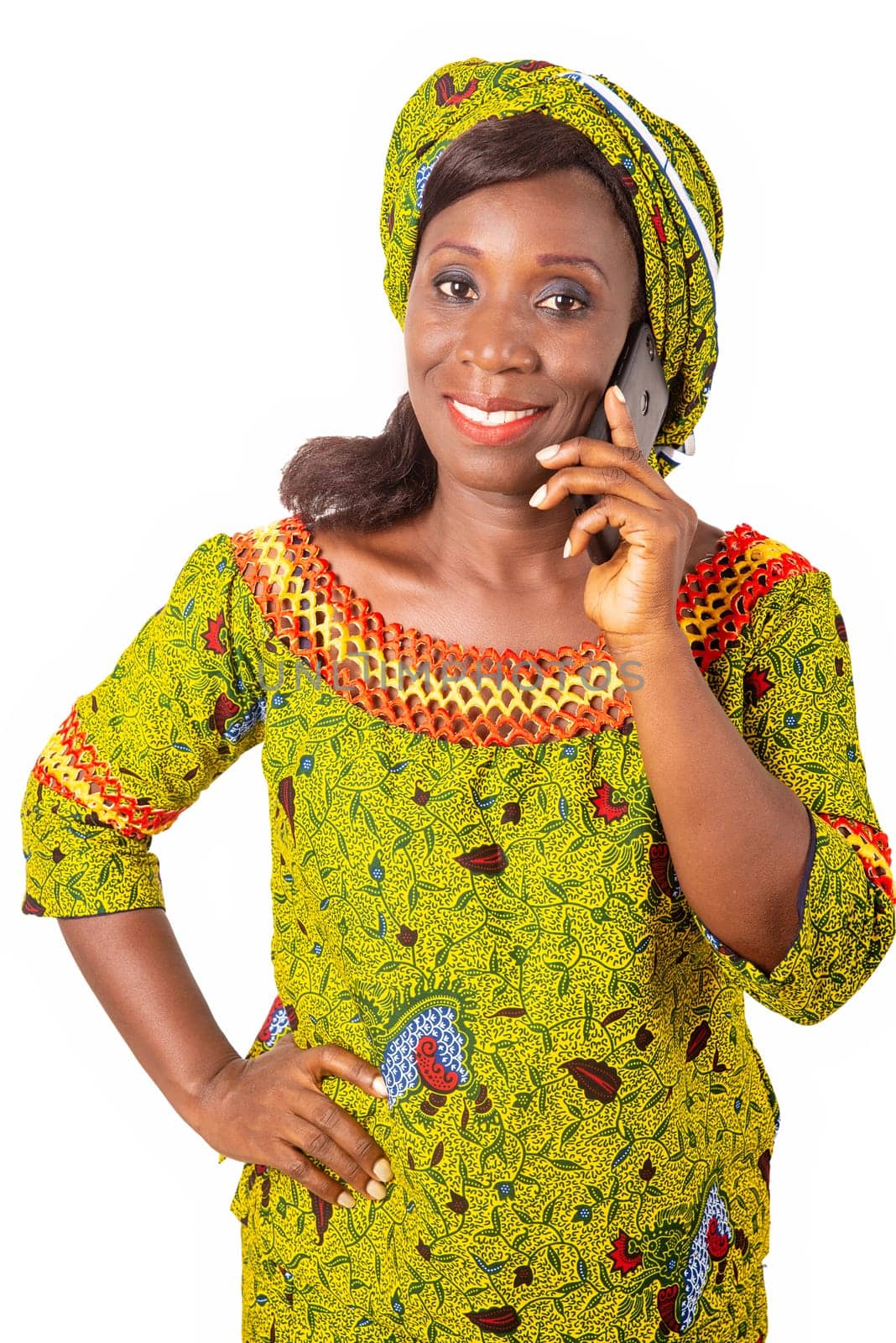 beautiful African adult woman wearing a green loincloth is phoning followed by a beautiful smile