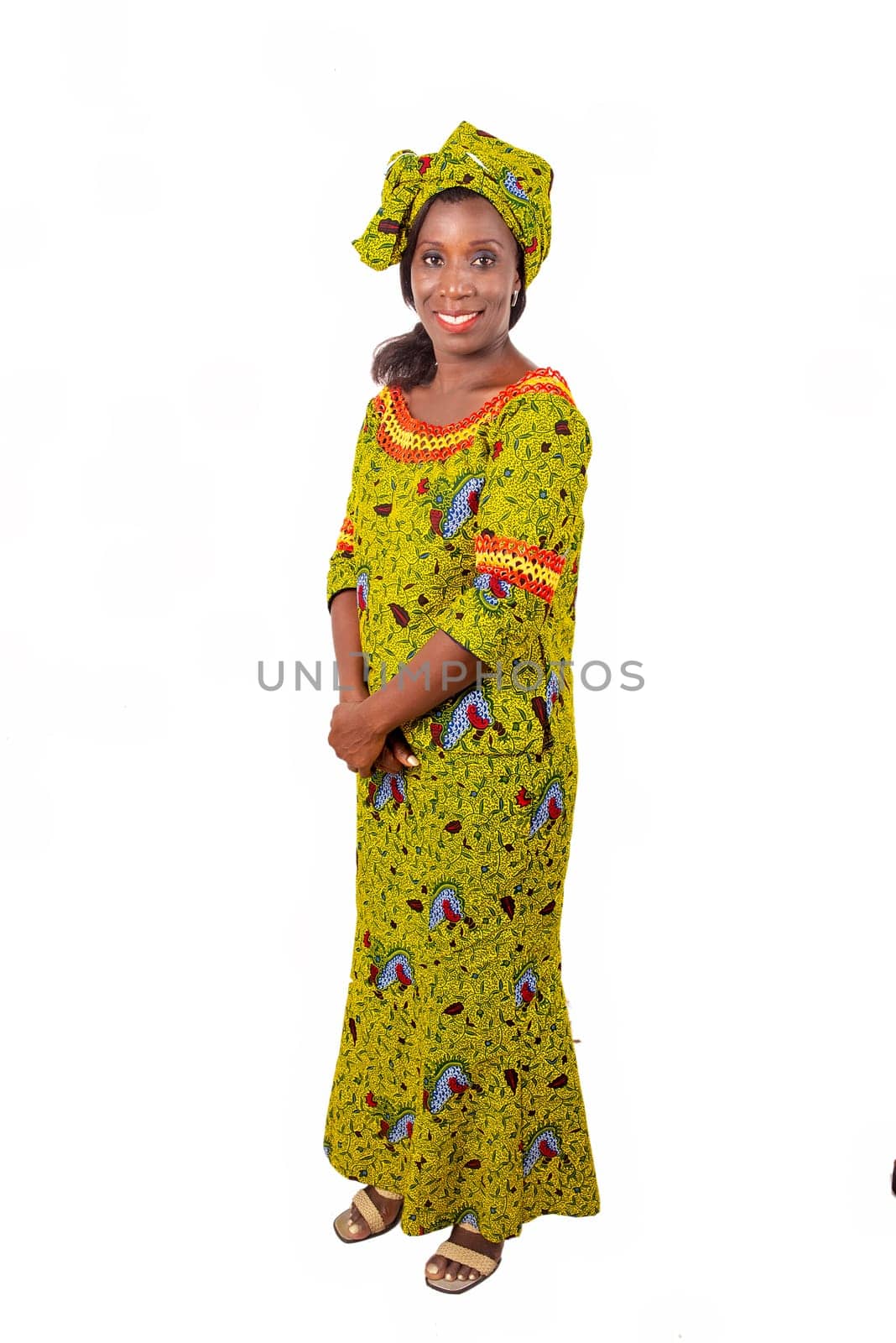 beautiful african adult woman wearing a green loincloth is smiling standing with her hands crossed