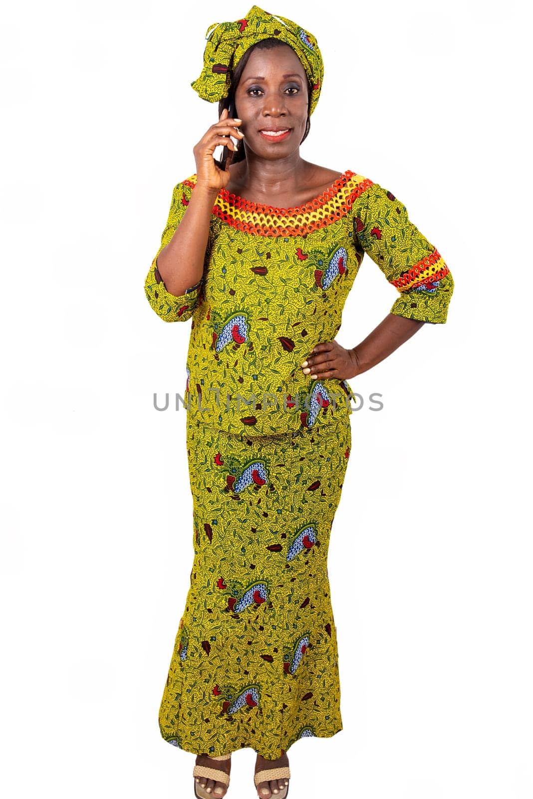 beautiful African adult woman wearing a green loincloth with heels on the feet is smiling on the phone while being arrested