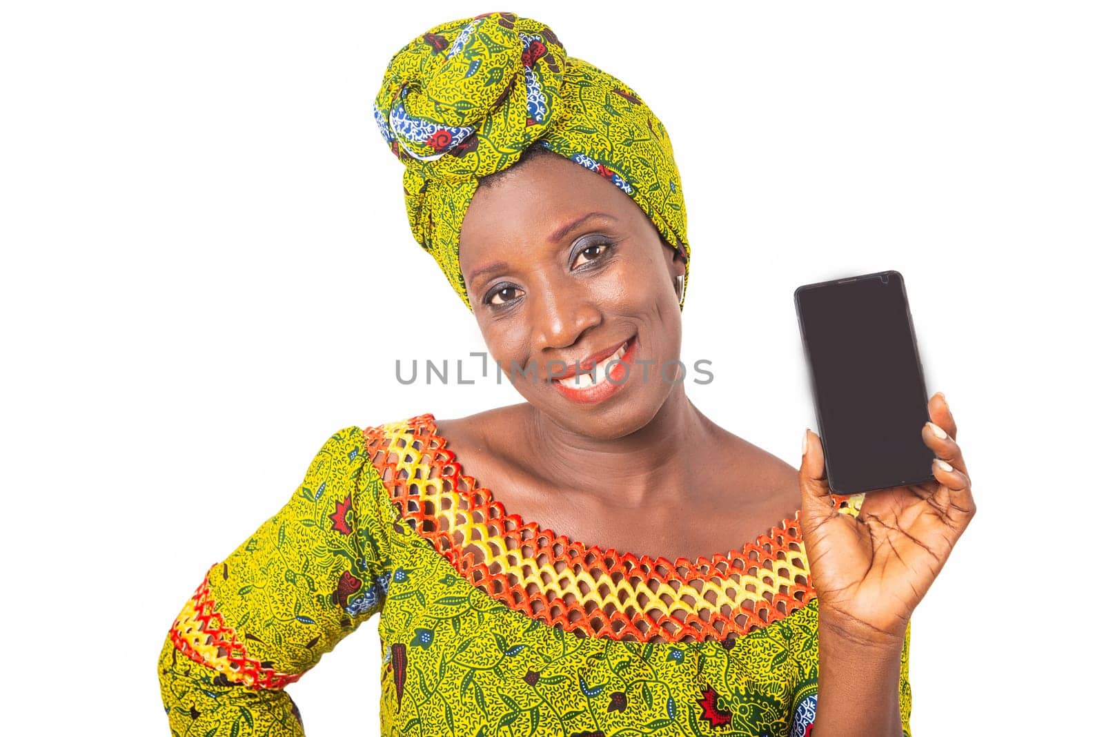 beautiful african adult woman dressed in green loincloth is smiling showing a mobile phone