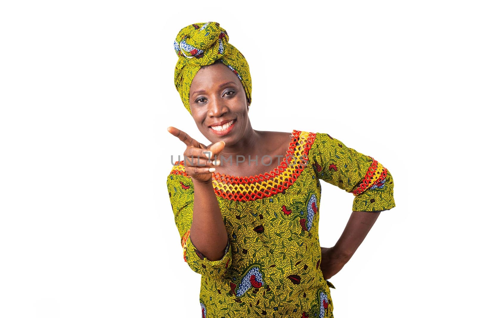beautiful african woman dressed in green loincloth with a scarf is happy and makes a gesture pointing the right finger forwards