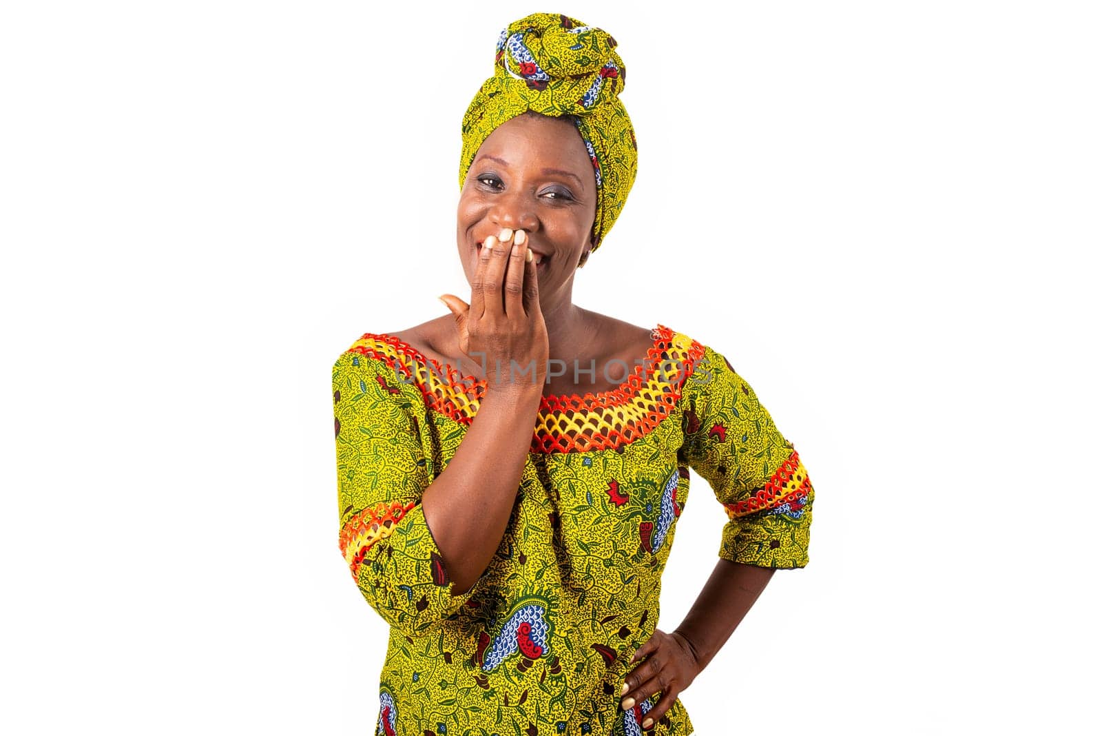 beautiful african woman dressed in green loincloth with a scarf on the head is happy putting her hand on the mouth with a crossed arm