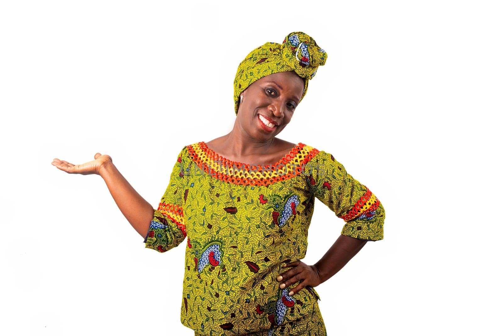 beautiful African adult woman dressed in loincloth and green scarf on the head is smiling with the raised hand and the arm on the hip