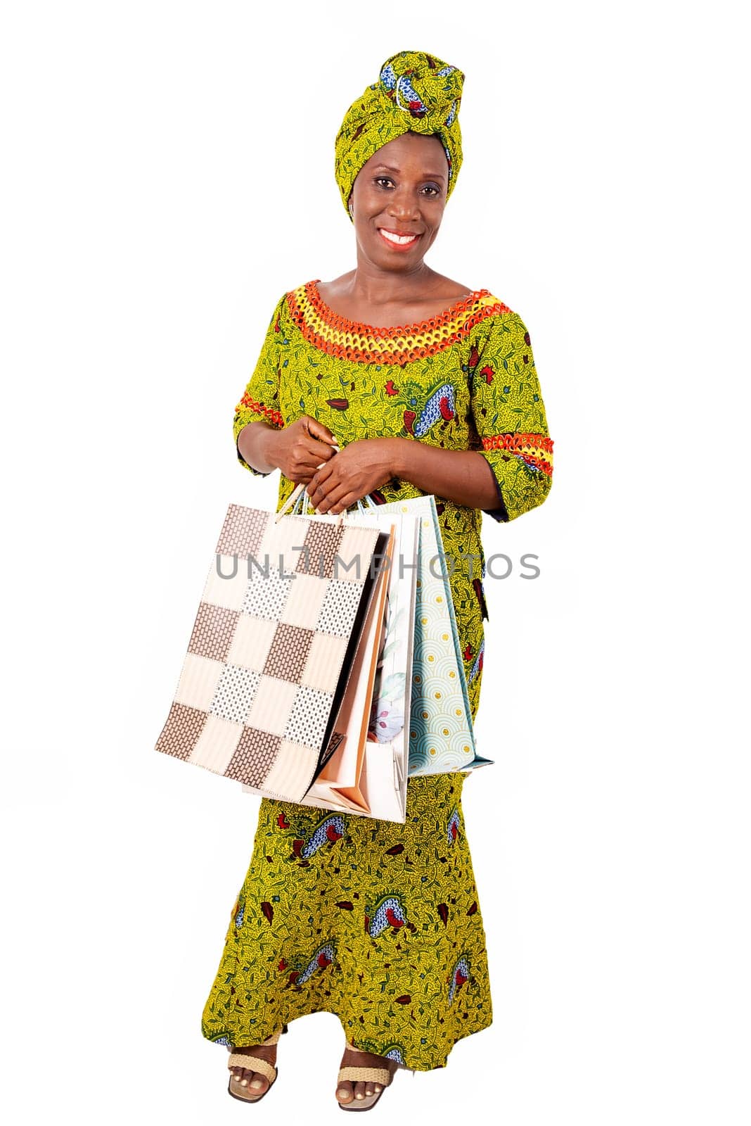 beautiful african adult woman wearing a loincloth and a green scarf is smiling and happy with shopping bags