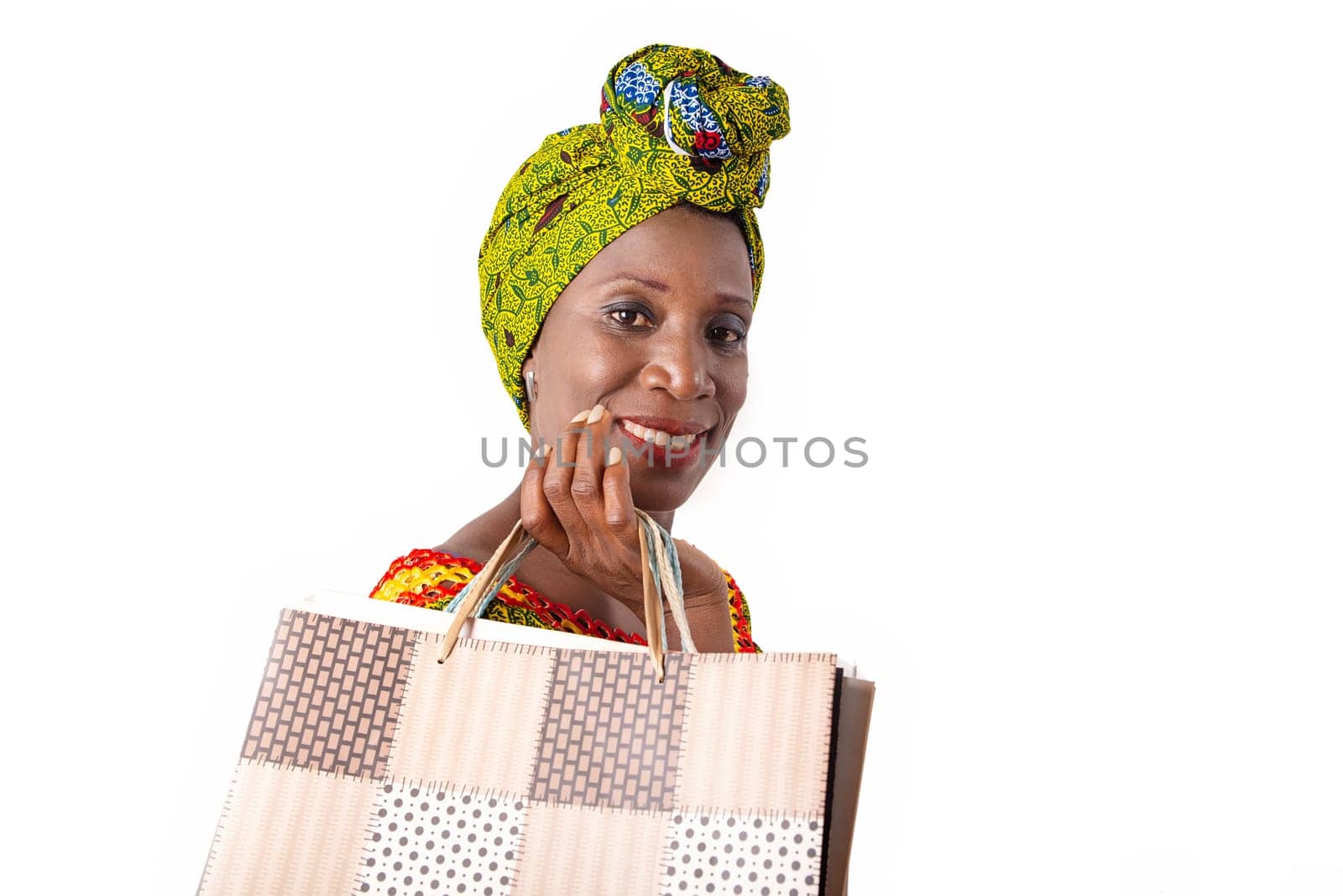 beautiful african adult woman wearing a loincloth and a green scarf is happy with shopping bags in hand