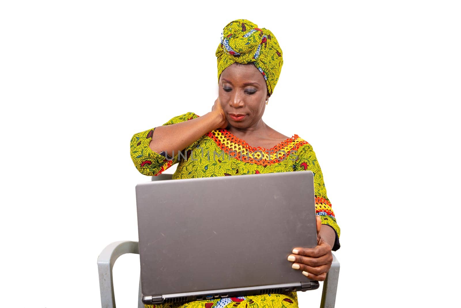beautiful mature woman sitting in traditional dress on white background looking at laptop.