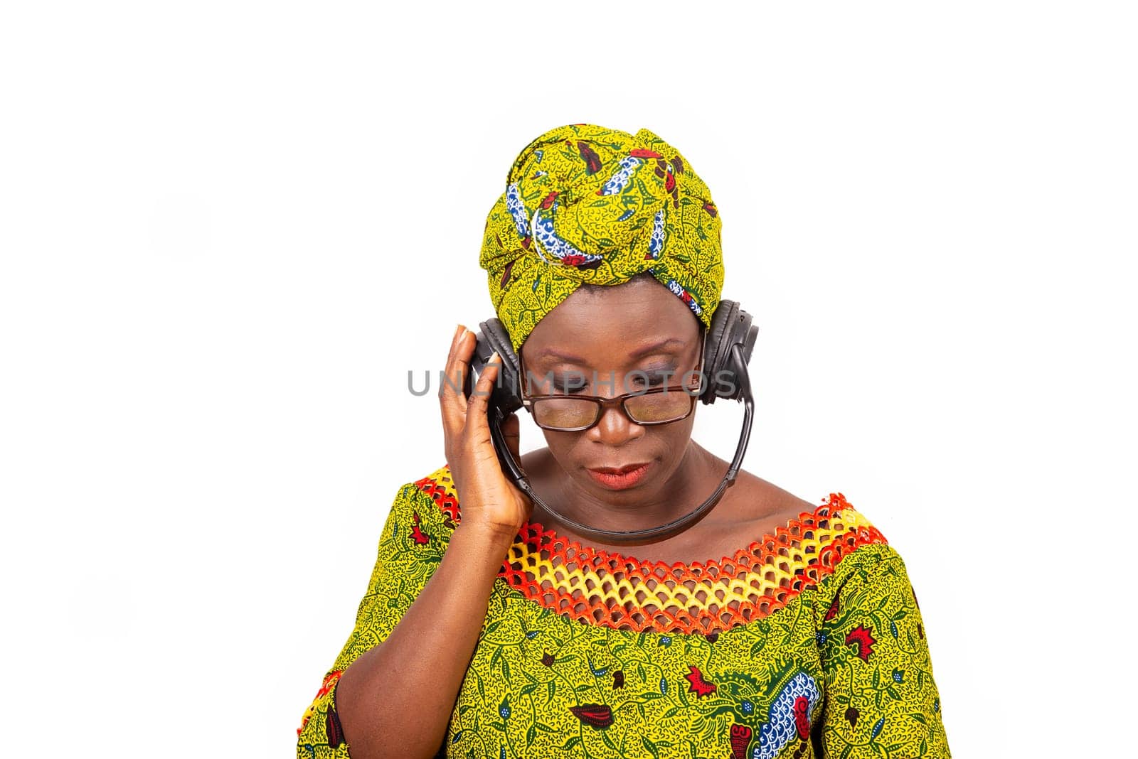 beautiful mature woman in eyeglasses isolated on white background communicating using headphones.