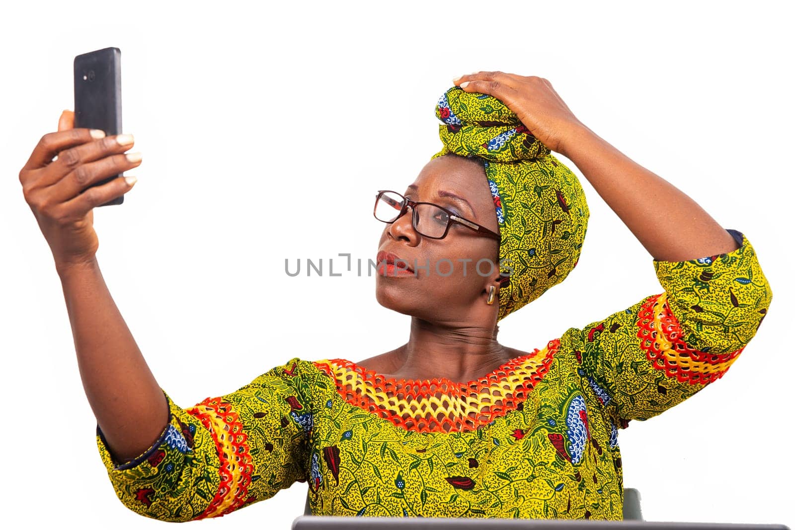 beautiful mature woman in eyeglasses isolated on white background go self-photographing using mobile phone.