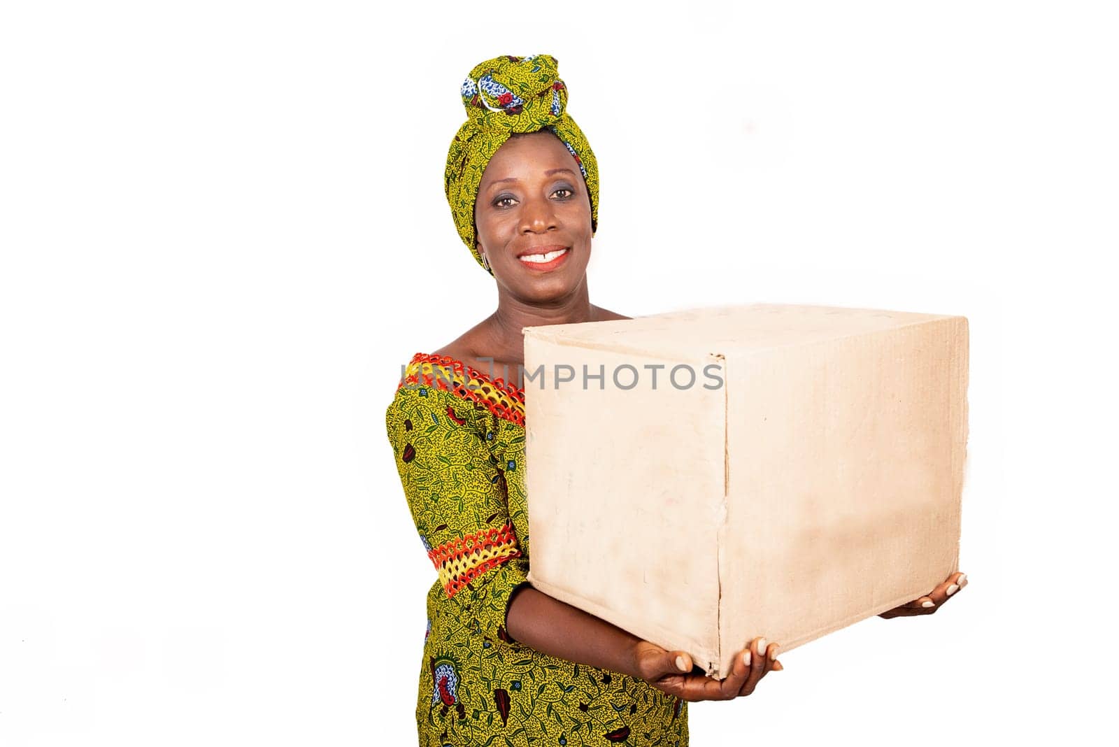 beautiful african adult woman wearing a loincloth and green scarf, smiling holding a cardboard box in the hand