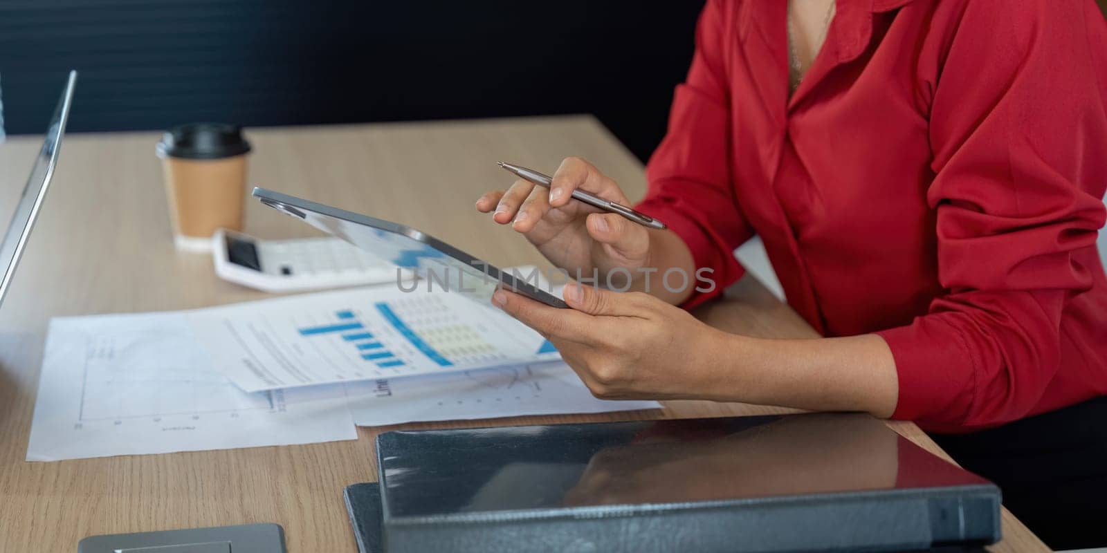 During a business meeting, a colleague evaluates detailed charts on a tablet, incorporating insights to drive informed decisions about financial strategies.