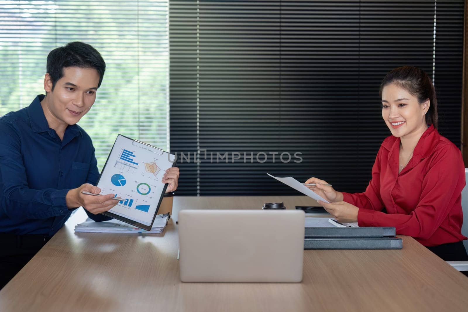 Two colleagues engage in a productive discussion about the latest financial data, enhancing business strategy.