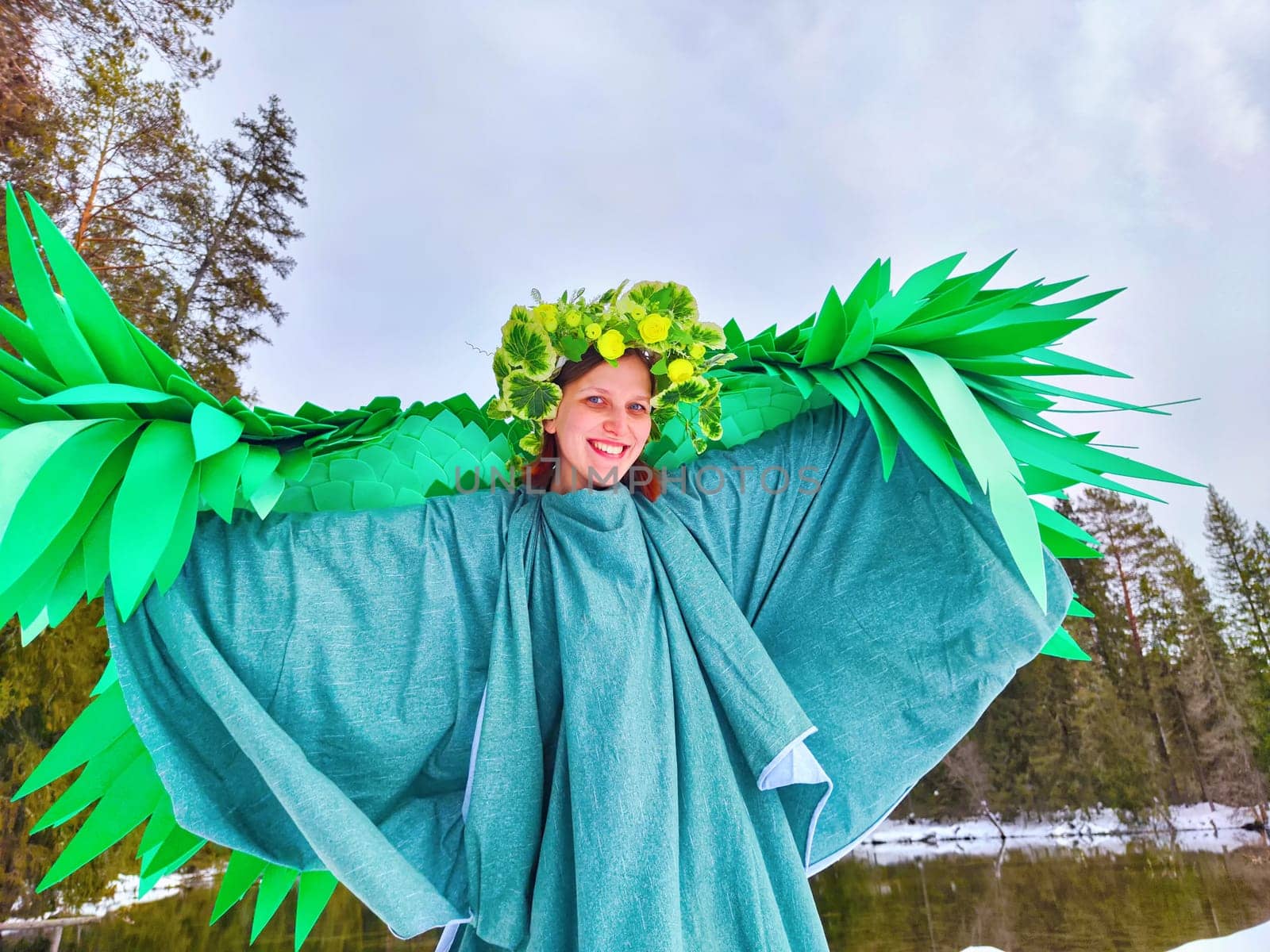 A girl dressed in a flowing green dress and leafy crown stands by a serene lake, capturing the essence of spring in a whimsical role-play.