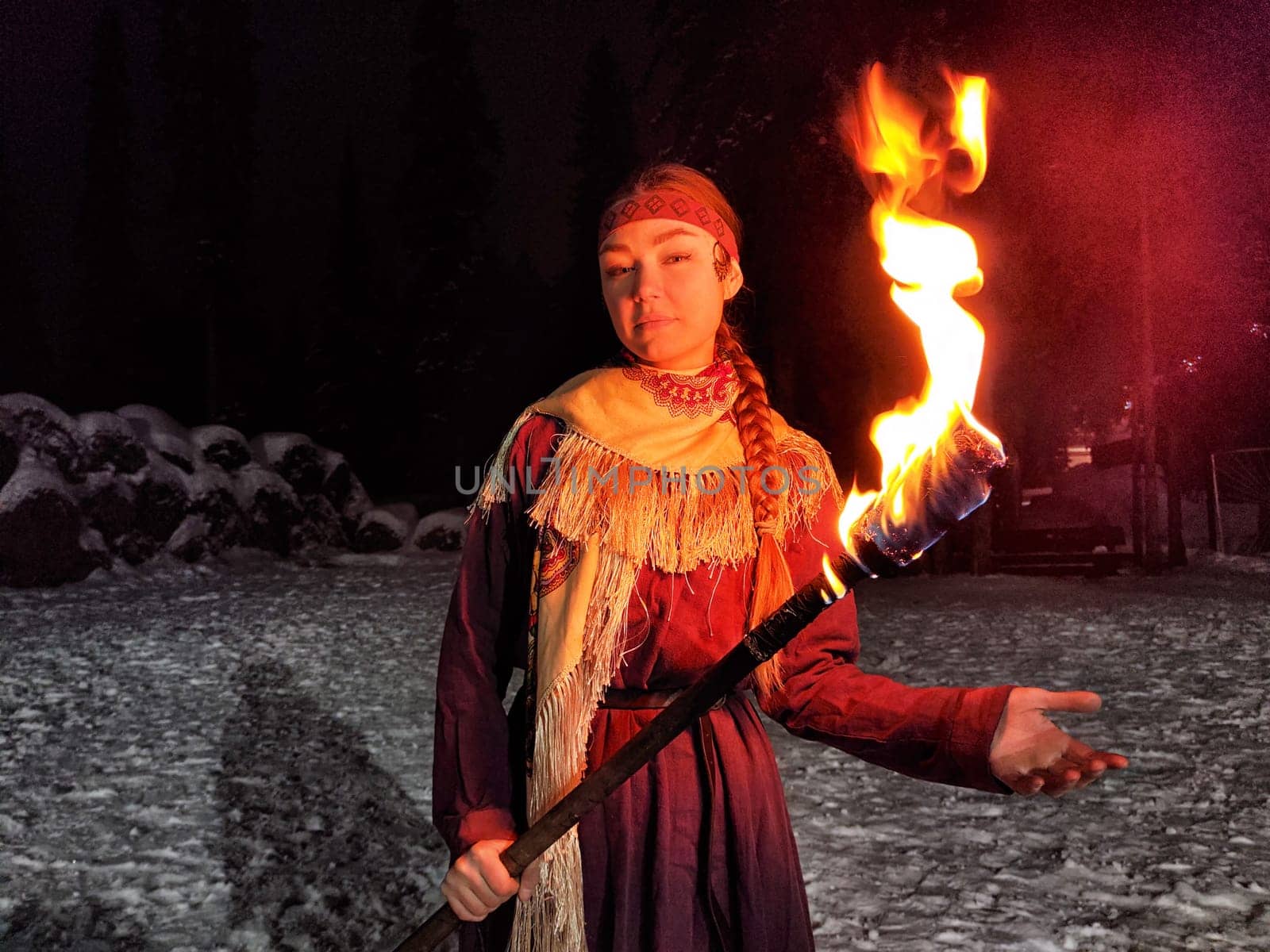 Actors in ethnic costumes perform a captivating fire show against a frosty winter backdrop, evoking the spirit of ancient warriors.