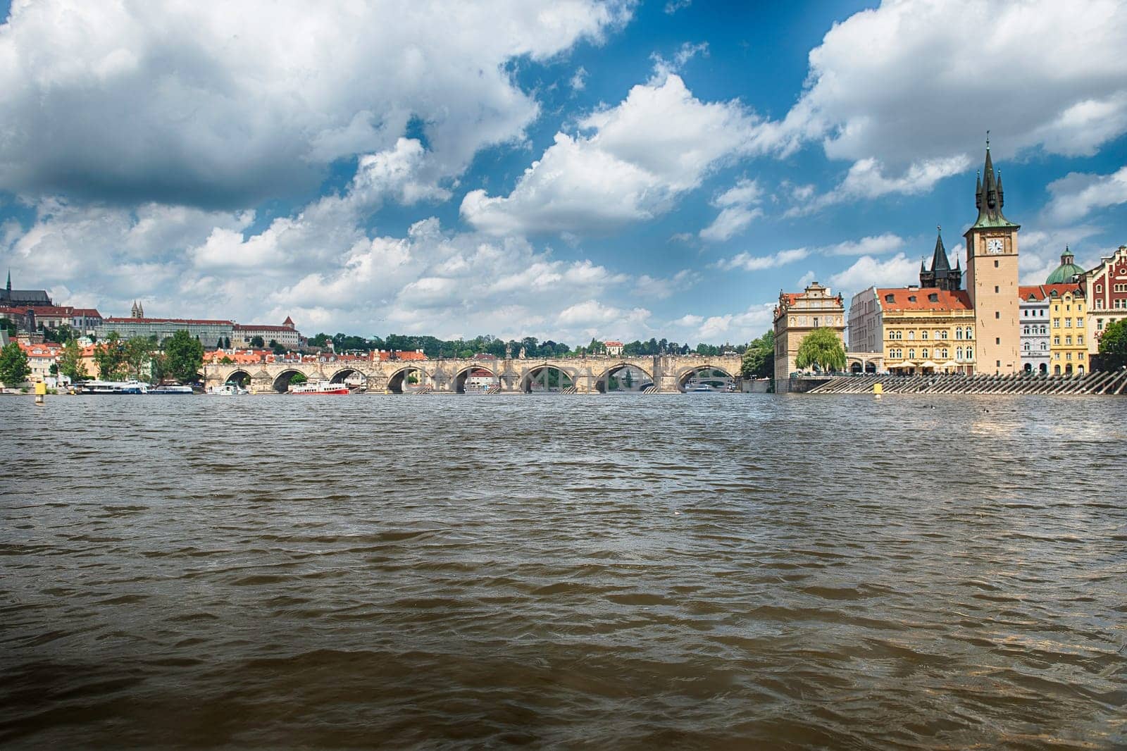 Charles Bridge crossing the Vltava River on a sunny day with the buildings of old town in the background in Prague, Czech Republic