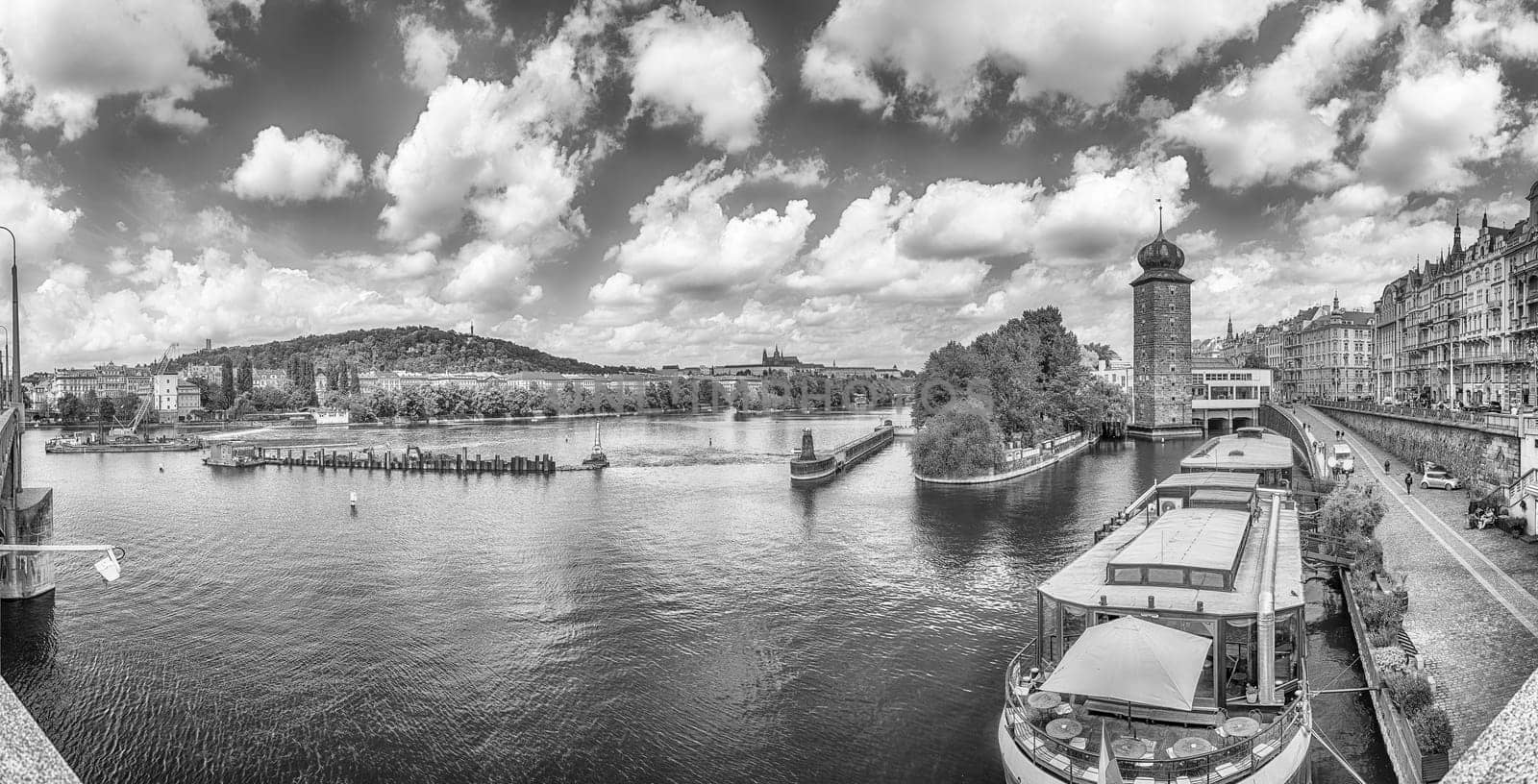 Panoramic view of Vltava River with tour boats and historic architecture in Prague, Czech Republic