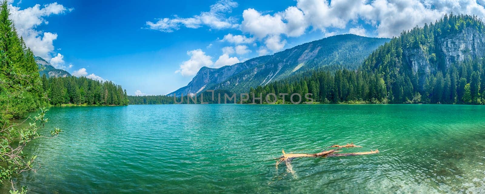 Panoramic view of the beautiful Lake Tovel with the Brenta Dolomites in the background on a sunny summer day, Trentino Alto Adige, Italy