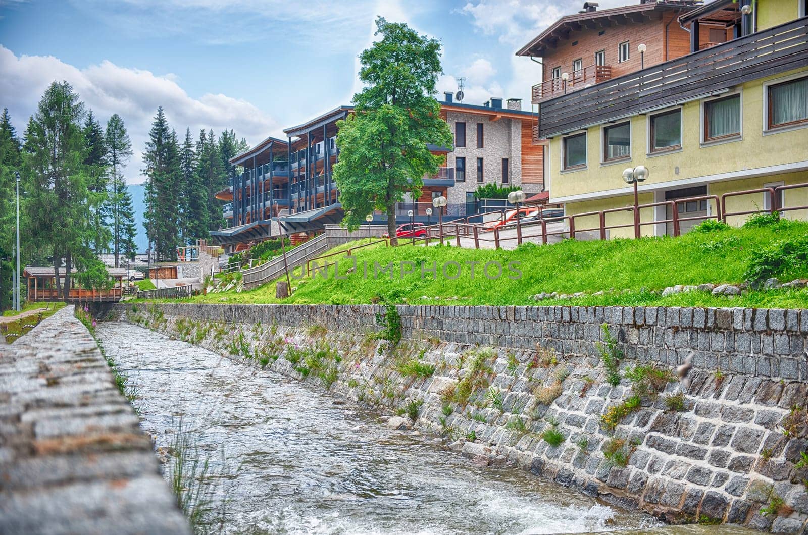 The city lake of Madonna di Campiglio reflecting the cloudy sky on a rainy day in summer, Trentino Alto Adige, Italy