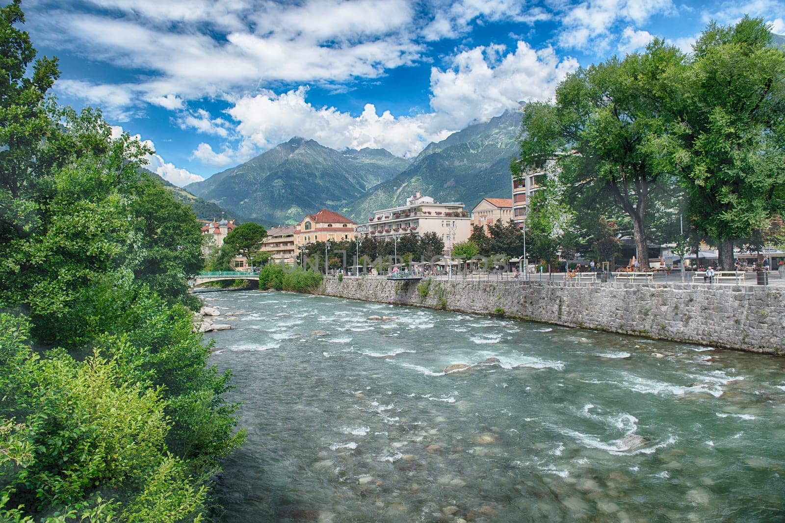 The Passirio River is flowing through the city center of Merano, a famous spa town in South Tyrol, Italy, surrounded by mountains