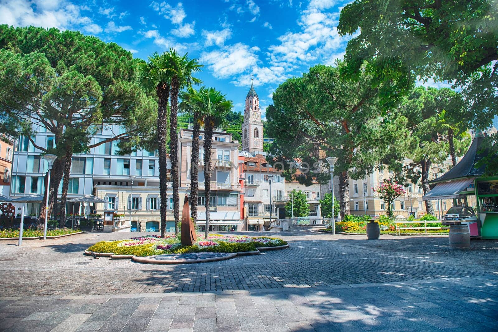 A sunny day walking down a pedestrian street lined with shops and restaurants in Merano, South Tyrol, Italy