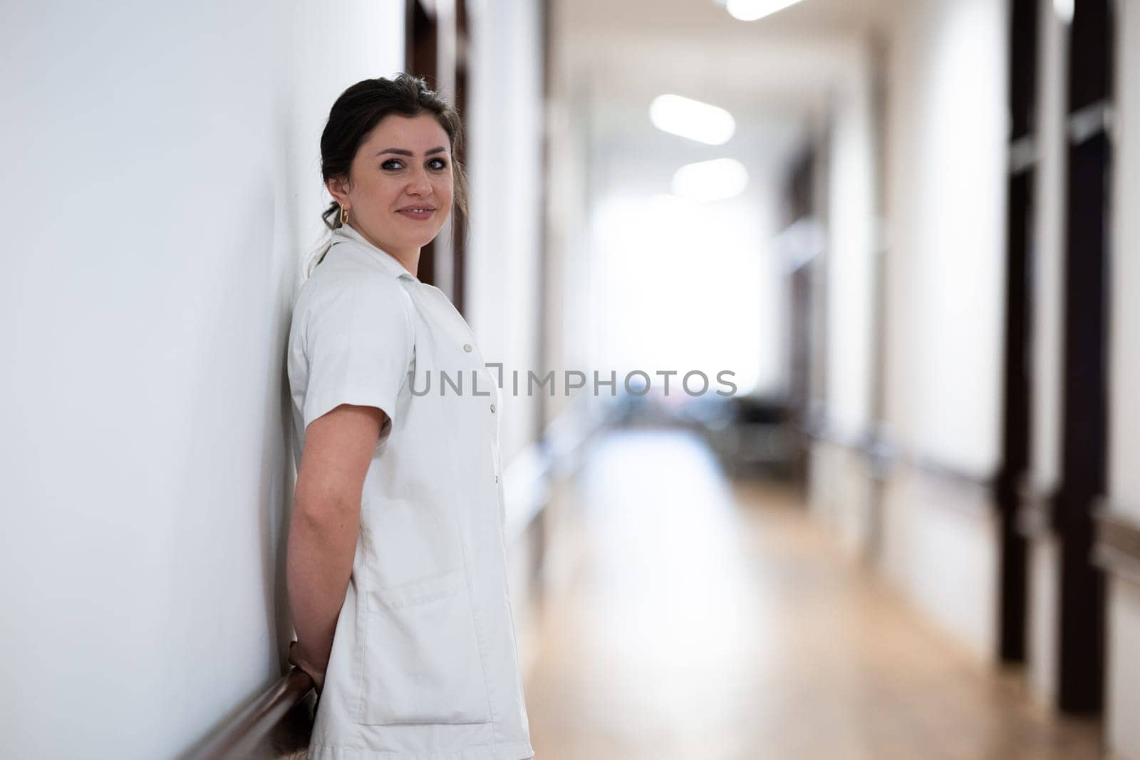 A tired nurse takes a quiet moment to rest in the hospital hallway, reflecting on a long and demanding shift