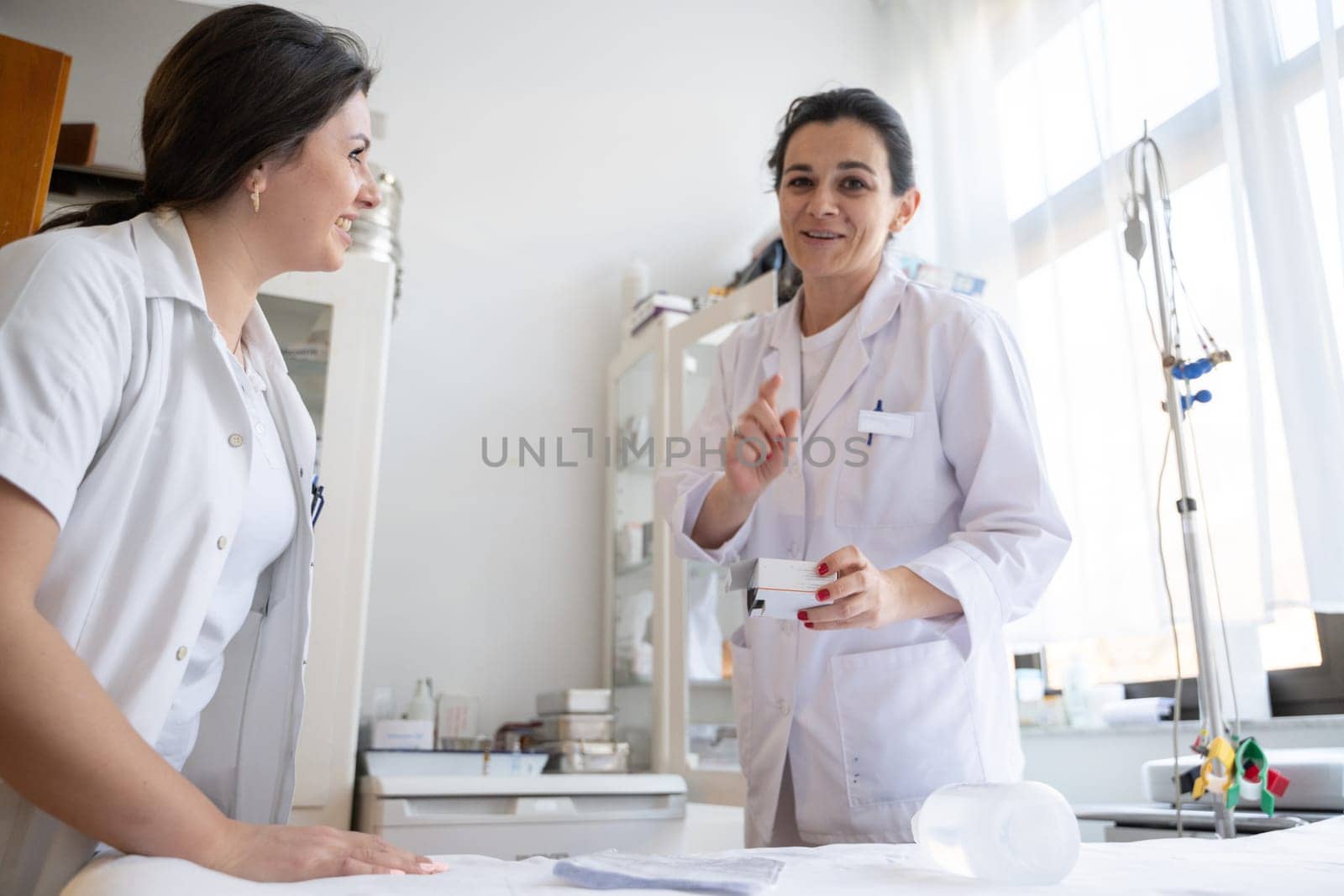 Two nurses in a hospital laboratory are carefully inspecting and preparing medications for patients and hospital use