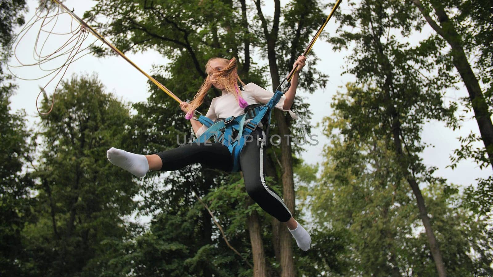 Teenage girl jumping on the trampoline bungee