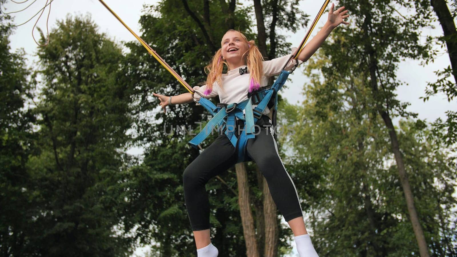 Teenage girl jumping on the trampoline bungee