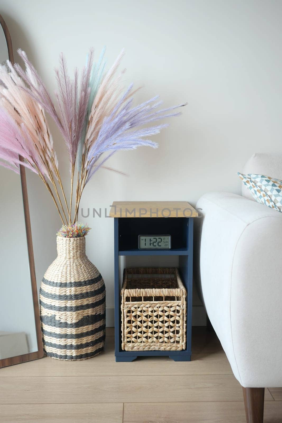 This cozy living room corner features a stylish flower arrangement and a clock.
